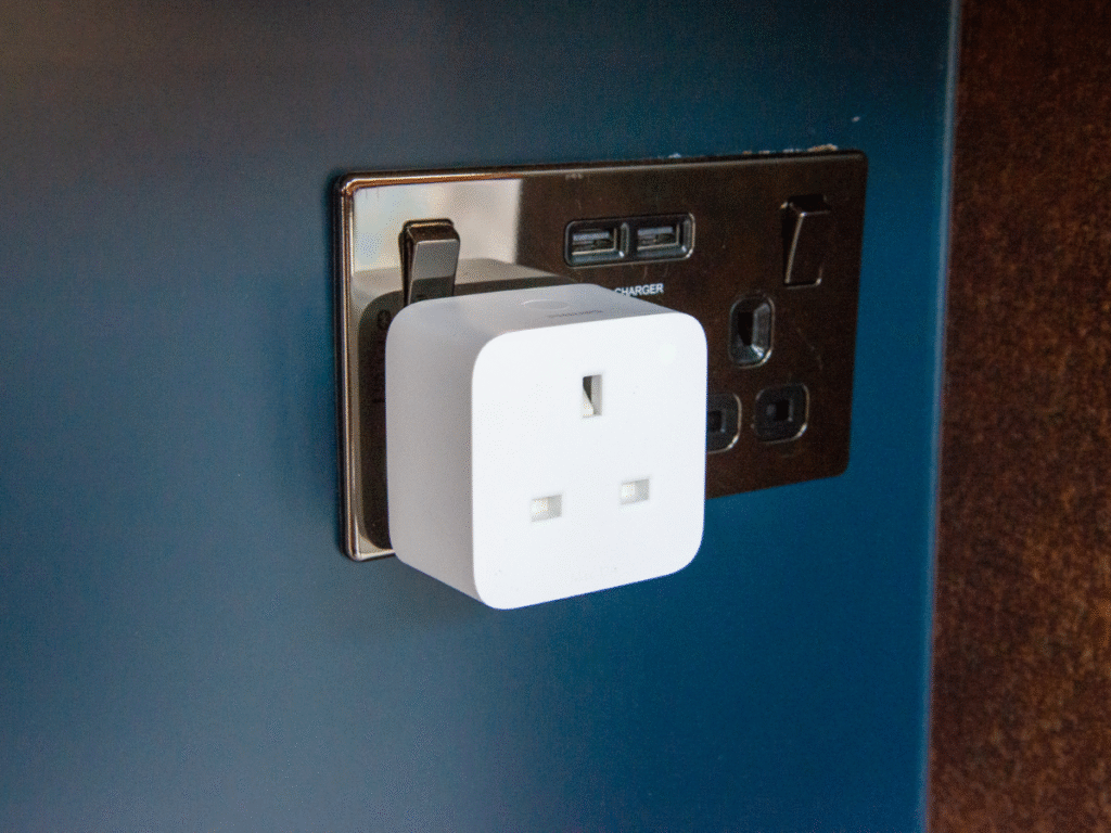 UK-style smart plug connected to a wall power socket, used for wireless control and energy monitoring.