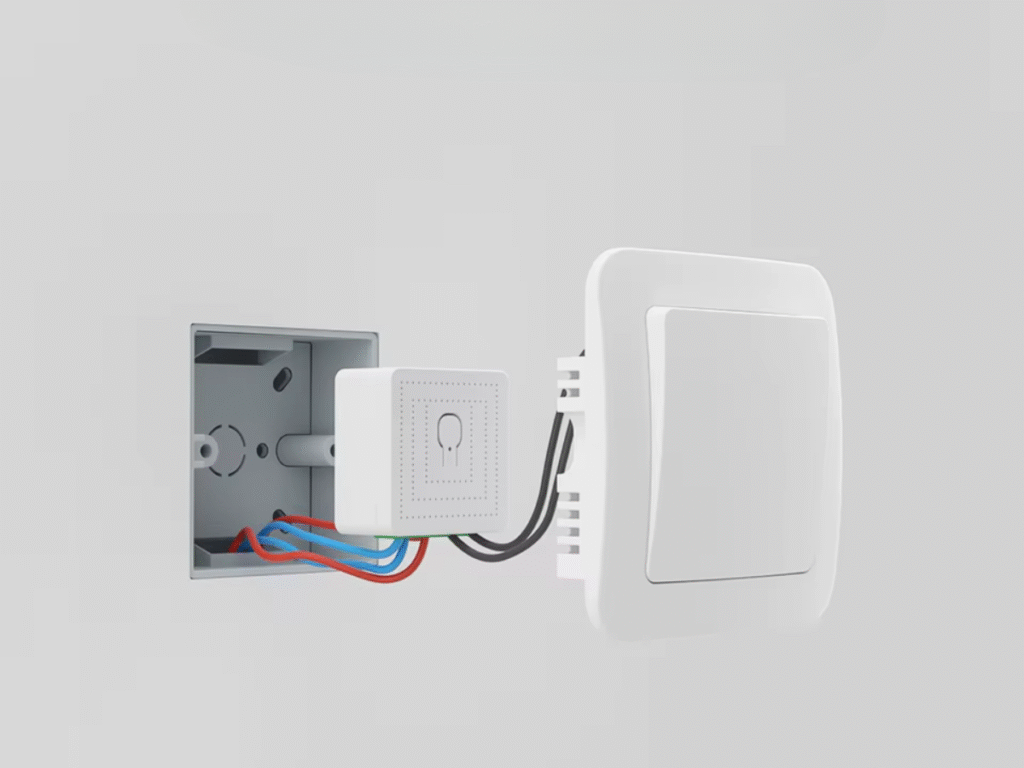 Smart in-wall relay module wired behind a traditional light switch inside a wall box.